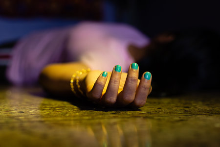An Indian or Asian woman dead body with outstretched hand lying on floor in a dark room