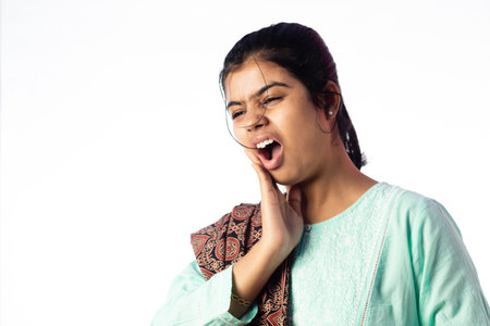 An Indian woman facing teeth problem showing painful expression on white background