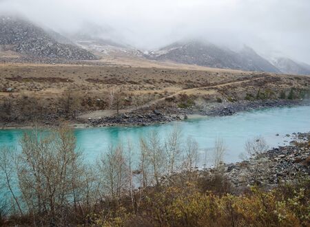 Turquoise river and fog in the mountainsの写真素材