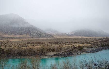 Turquoise river and a fog in the mountainsの写真素材