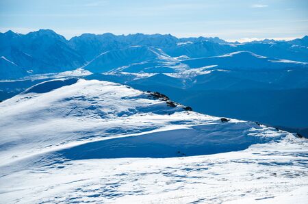 White snow hills of mountains and a blue skyの写真素材