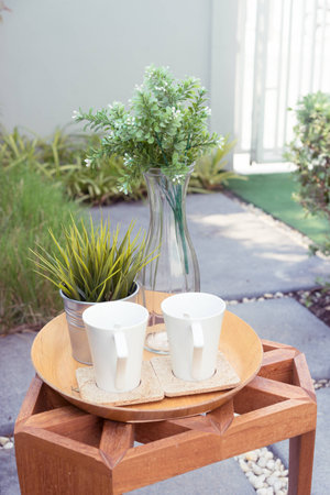 cup ,flowerpot on wooden furniture in terrace garden