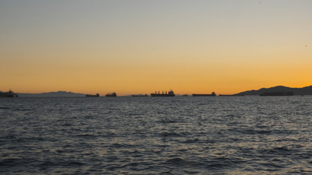 Silhouettes of large ships at the sea harbor at sunset. Tankers on the horizonの写真素材