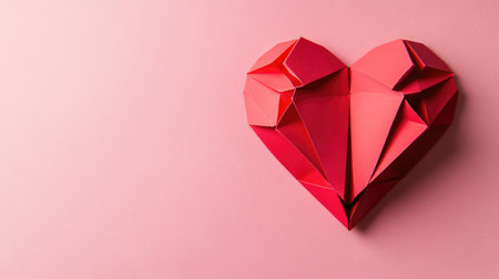 Red paper origami heart on pink background. St. Valentine's day concept. Symbol of love, romance and passion.の素材