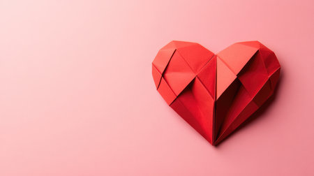 Red paper origami heart on pink background. St. Valentines day concept. Symbol of love, romance and passionの素材