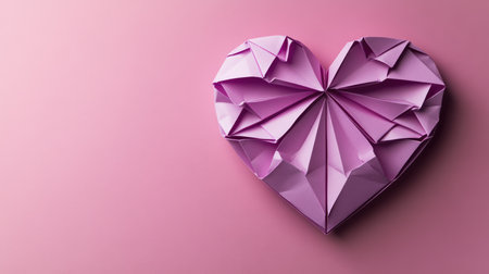 Violet paper origami heart on pink background with copy space. St. Valentine's day concept. Symbol of love, romance and passion.の素材