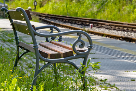 Bench at a small narrow-gauge railway station -on the background of the railway track. selective focusの写真素材