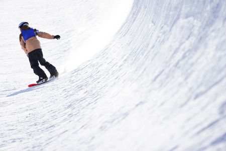 A snowboarder finishes a run in the half pipe