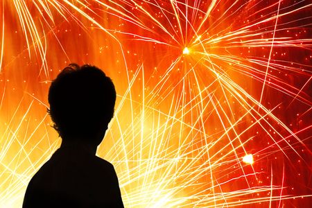 Silhouette of a child watching a fireworks displayの写真素材