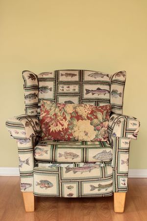 A tacky Arm Chair with a fish pattern well worn and broken inの写真素材