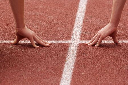 Hands poised at the starting line of a raceの写真素材