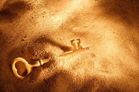 A skeleton key in a mound of sandの写真素材