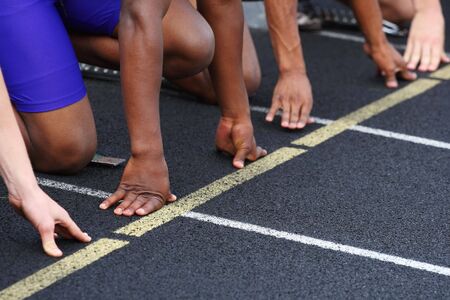 A close up of the hands of runners on the starting line