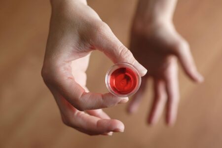 a hand holds a comunion cup with wineの写真素材