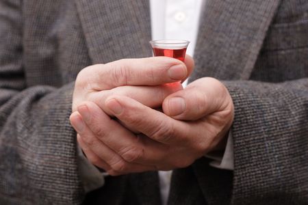 a man is holding a comunion cup with wine