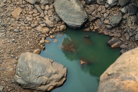 turquoise color water body and big rocks and small different shape stones in valley and habitat of...