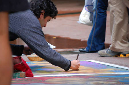 A man drawing on a canvas layed on the ground - in Pitt street sydney のeditorial素材