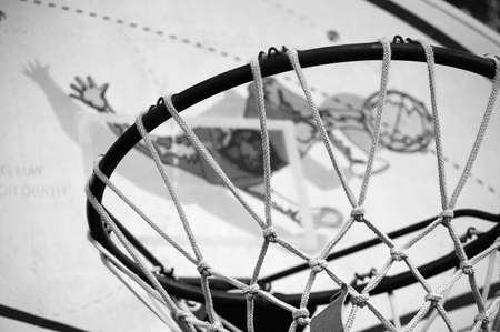 Black and white picture of a basketball ring and net.