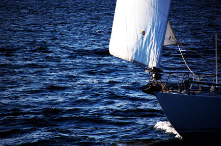 A boat moves across the darkening waters.