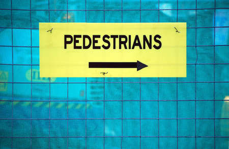 A pedestrian sign in front of a construction site directing walkers by in the right direction.の写真素材