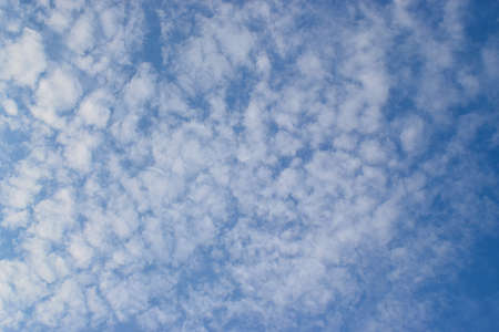vibrant blue sky with white puffy clouds floating , awesome image for background useの写真素材