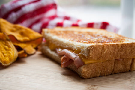 Grilled ham and cheese on a wooden cutting boardの写真素材
