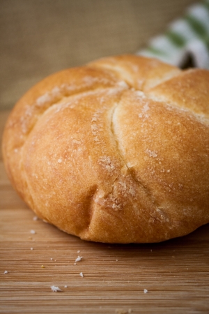 A fresh Kiaser roll on a bamboo cutting board