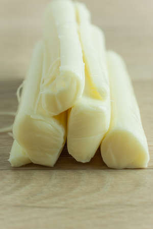 Sticks of mozzerella string cheese on a light colored table top.の写真素材