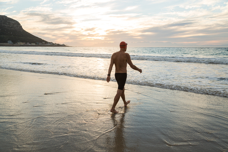 Senior man, aged 65, preparing to swim in the sea at dawnの写真素材