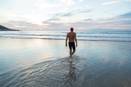 Senior man, aged 65, preparing to swim in the sea at dawnの写真素材