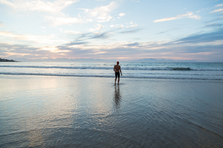 Senior man, aged 65, preparing to swim in the sea at dawnの写真素材