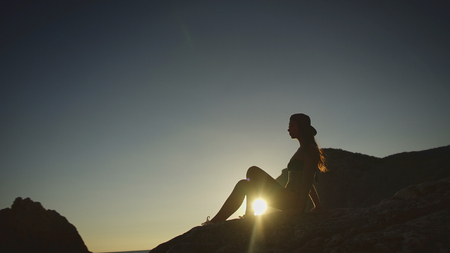 Woman sets on the beach on sunset, outdoor shootの写真素材