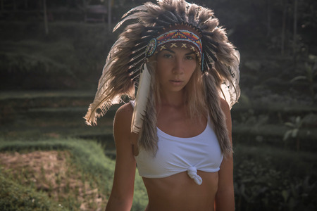Close up of good looking European woman wearing war bonnet with feathers,の写真素材