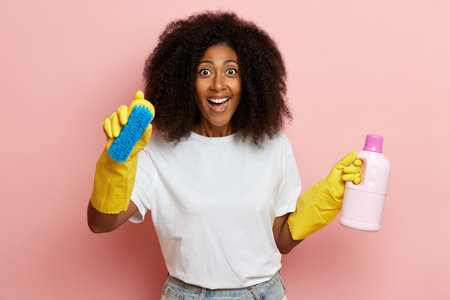 happy housewife, finishing her cleaning process, she wears white t-shirt and yellow cleaning gloves. High quality photoの写真素材
