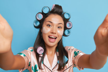 Happy student girl at home wearing pijamas, taking selfie, smiling, girl having video call with friends, good mood concept, copy spaceの写真素材