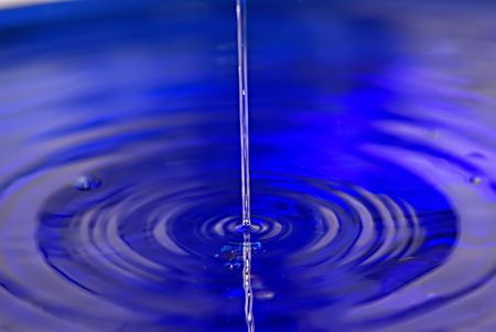 Fresh liquid from water drop in a blue cup           