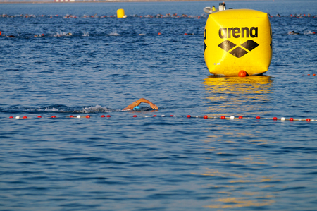 NICE - JULY 27, 2017: IRONMAN Nice 2017. 3,8 km swim in the Mediterranean Sea. CHEVROT arriving first at beach.のeditorial素材