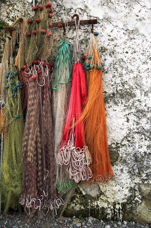 Few colored fishing nets laid outdoor on a white wallの写真素材