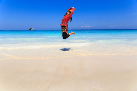 Asia woman jumping on tropical beach and white sand beach, Similan Island, Koh Ta Chai, Andaman Sea, Thailandの写真素材