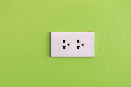 simple white electric usa socket on green wallの写真素材