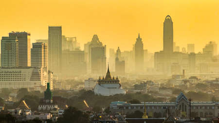 Golden Mountain Pagoda, an ancient temple, Wat Saket in Bangkok in the morning behind a high-rise business district. edit warm toneの写真素材