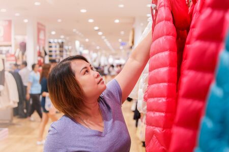 Asian woman shopping in clothing store.の写真素材