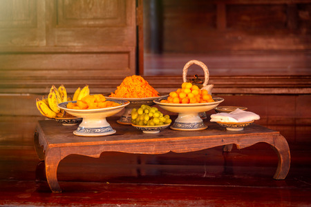 Many thai desserts (khanom wan thai) and fruits on the old wood table. Fractal on the earthenware is...