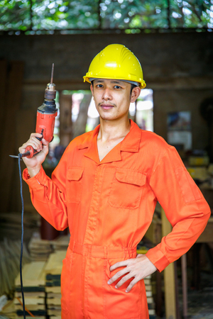 Asian young man of mature carpenter in the workshopの写真素材