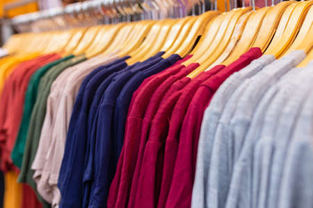 A rack of colorful shirts hanged for sale at local market.