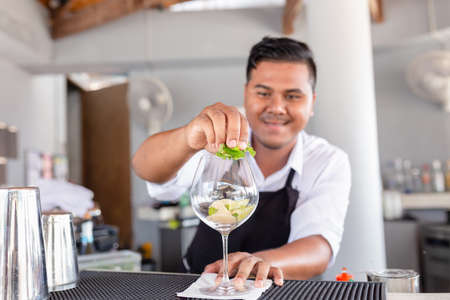 Bartender is making cocktail at counter bar.の写真素材