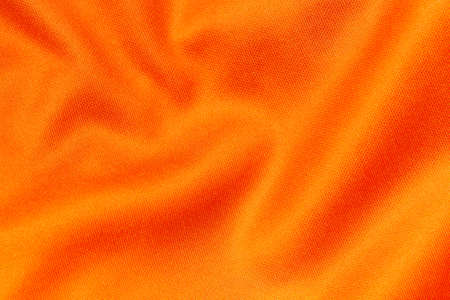 Orange color sports clothing fabric football shirt jersey texture and textile background.