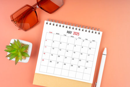 May 2025 desk calendar with brown sunglasses on beautiful background.の写真素材