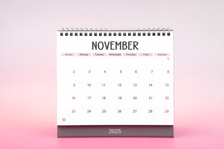 Desktop monthly calendar for November 2025 on pink color background.の写真素材