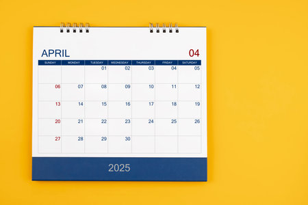 April 2025 desk calendar on the yellow table, planning for business meeting or planning concept.の写真素材